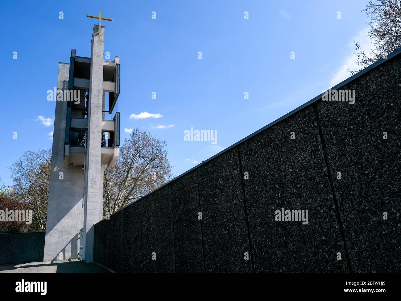 17 aprile 2020, Berlino: Maria Regina Martyrum, chiesa cattolica romana a Charlottenburg con la torre della chiesa con camera da campana. Fu costruita tra il 1960 e il 1963 come "Chiesa dei cattolici tedeschi in onore dei testimoni di sangue della libertà di fede e di coscienza negli anni 1933-1945", martiri del tempo del socialismo nazionale. Sulla facciata sopra l'ingresso è appesa la scultura in tre parti "Donna Apocaliptica" in bronzo dorato. La chiesa commemorativa Maria Regina Martyrum con il suo campanile e il cortile è un monumento registrato. Foto: Jens Kalaene/dpa-Zentralbild Foto Stock