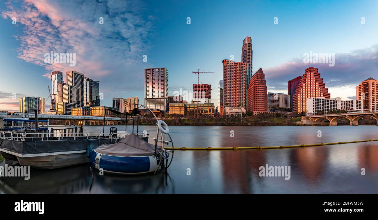 Panorama con gli alti alti alti alti del centro che riflettono il tramonto luce d'ora dorata vista attraverso Lady Bird Lake o Town Lake sul fiume Colorado a Austin, Texas USA Foto Stock