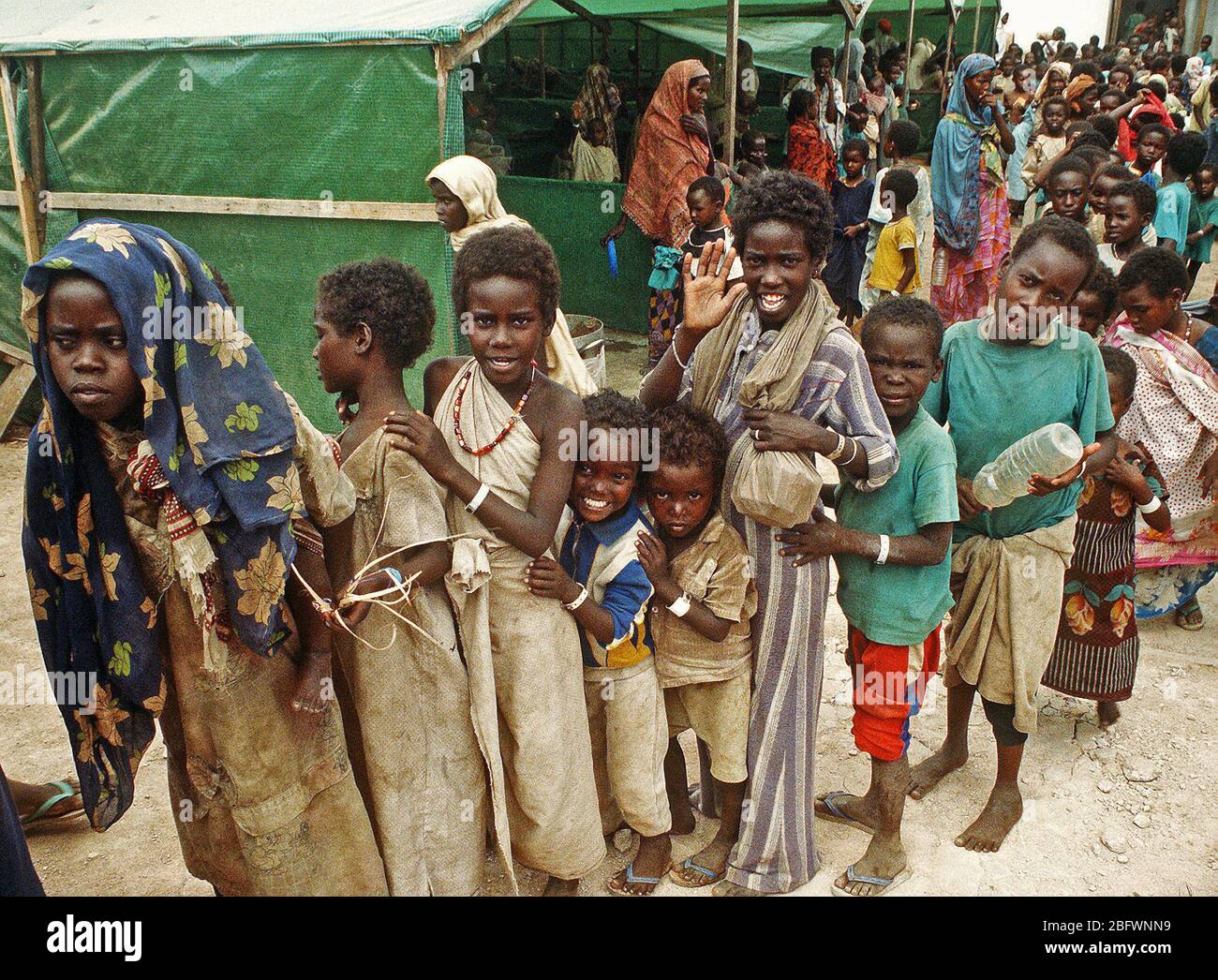 Bambini stare in linea in corrispondenza di una stazione di aiuto durante la multinazionale soccorsi Restore Hope. Foto Stock