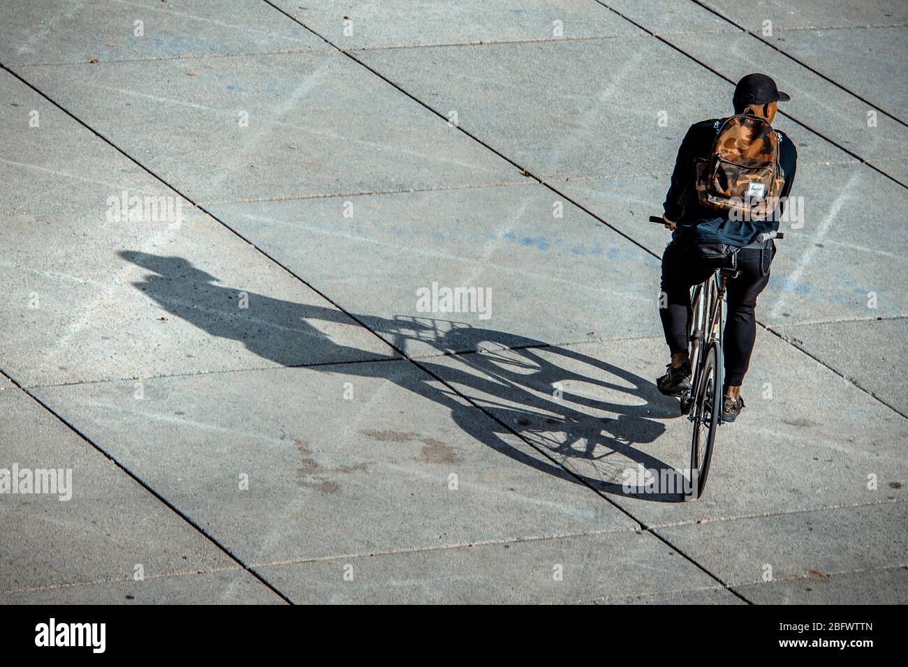 Uomo che guida una bicicletta in ambiente urbano Foto Stock