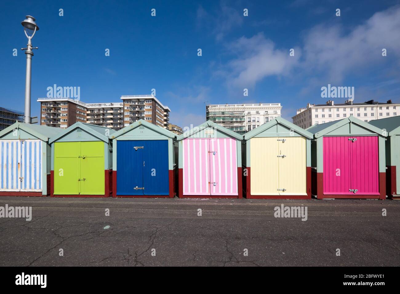 Capanne sulla spiaggia di Hove a Brighton, Sussex, Regno Unito, con edifici di appartamenti sullo sfondo Foto Stock