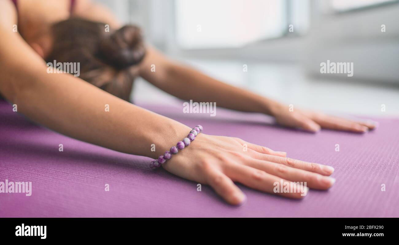Meditazione yoga a casa sul tappetino da ginnastica stretching facendo posa del bambino come riscaldamento per la calma consapevolezza durante stressante COVID-19 pandemic. Banner panoramico. Foto Stock