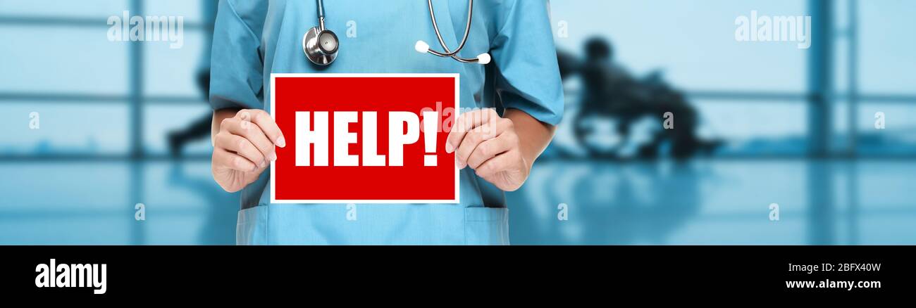 Medico o infermiere che mostra il cartello di aiuto sul banner blu dell'ospedale. COVID-19 lavoratori di emergenza in caso di focolai. Medico di coronavirus che tiene bordo panoramico del testo del virus corona titolo. Foto Stock