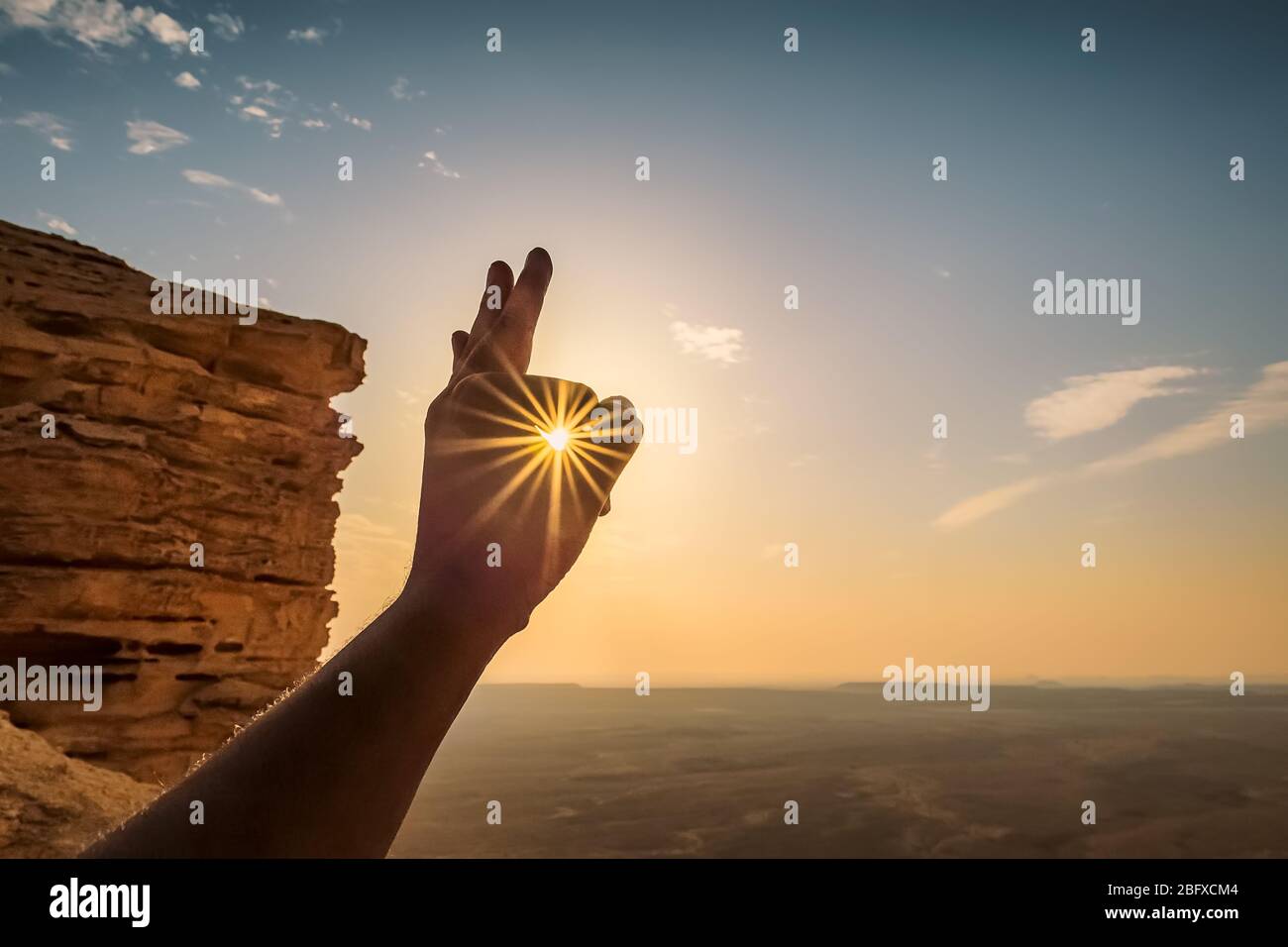 Sole raggi attraverso le dita - bordo del mondo Arabia Saudita. ( concentrazione selettiva su soggetto e sfondo sfocati) Foto Stock