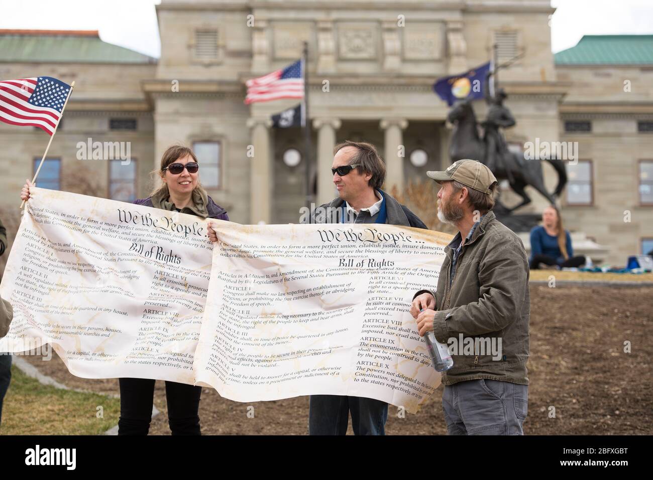 Helena, Montana - 19 aprile 2020: Un uomo una donna protesta in possesso di striscioni della carta dei diritti di fronte al palazzo del Campidoglio a una protesta del Foto Stock Helena, Montana - 19 aprile 2020: Un uomo una donna protesta in possesso di striscioni della carta dei diritti di fronte al palazzo del Campidoglio a una protesta del Foto Stock