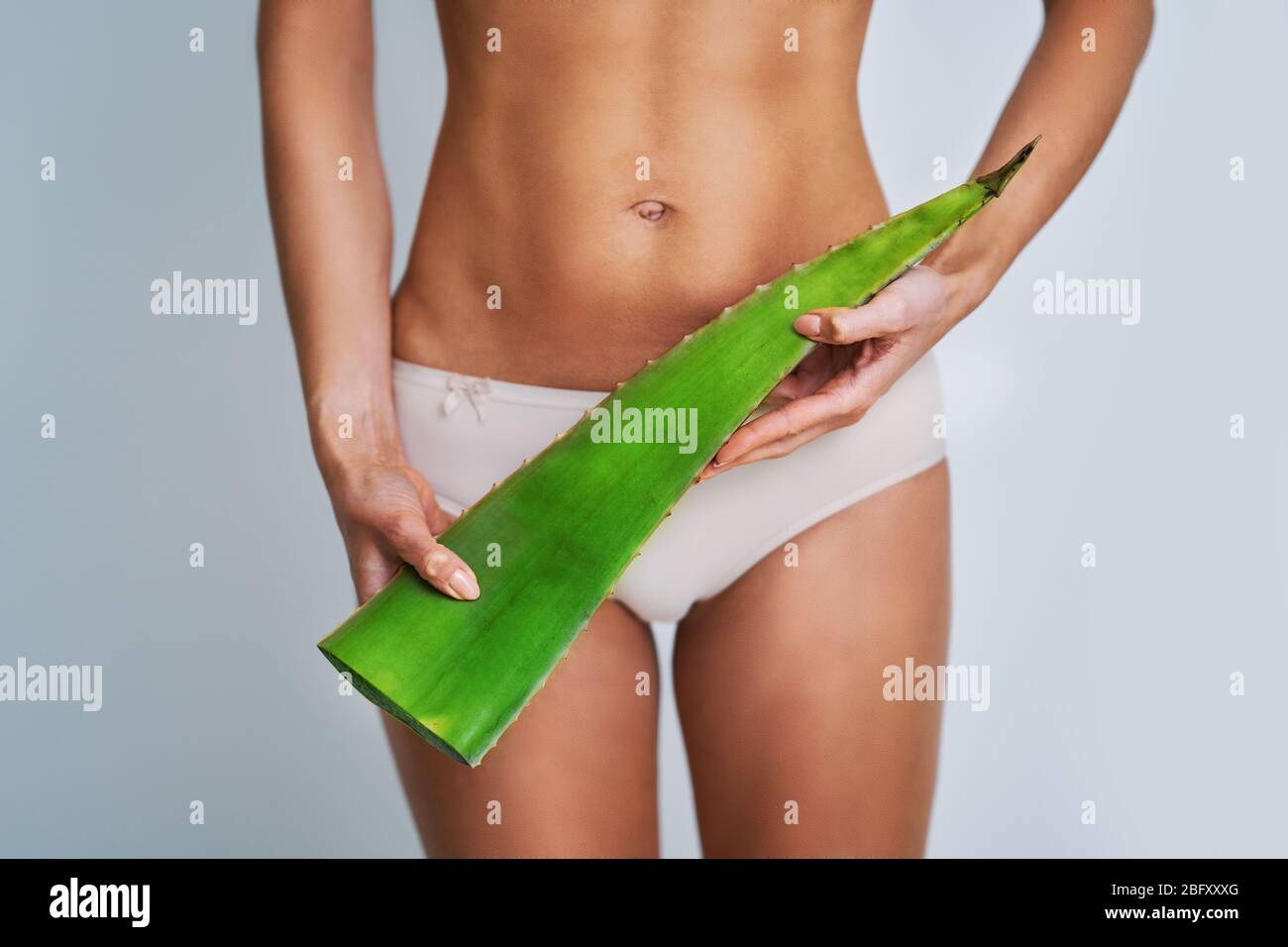 Bella donna adulta in posa naturale con aloe vera foglia Foto Stock