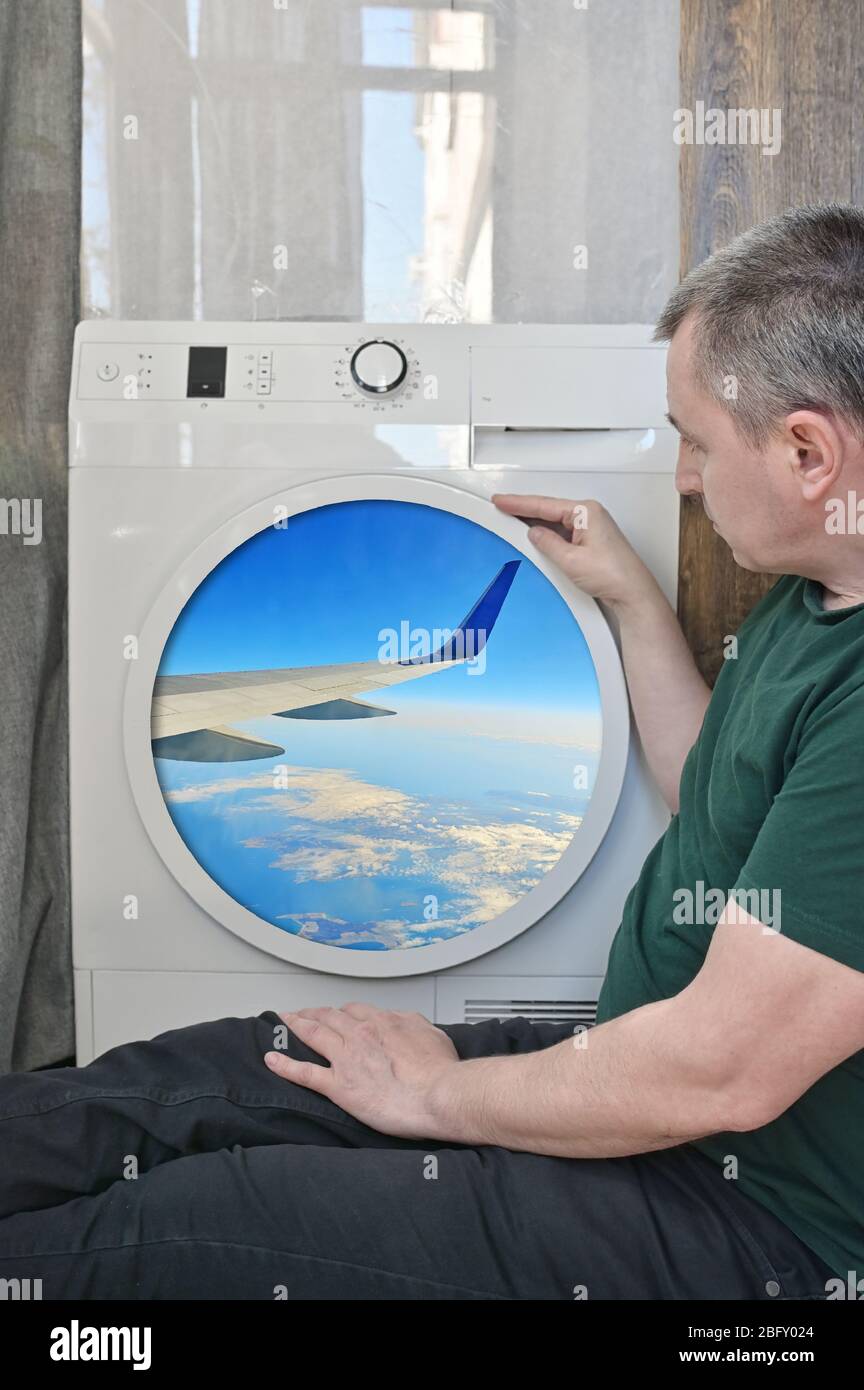 Isolamento passeggero maschio guardando attraverso UNA finestra di lavaggio come un aereo Foto Stock