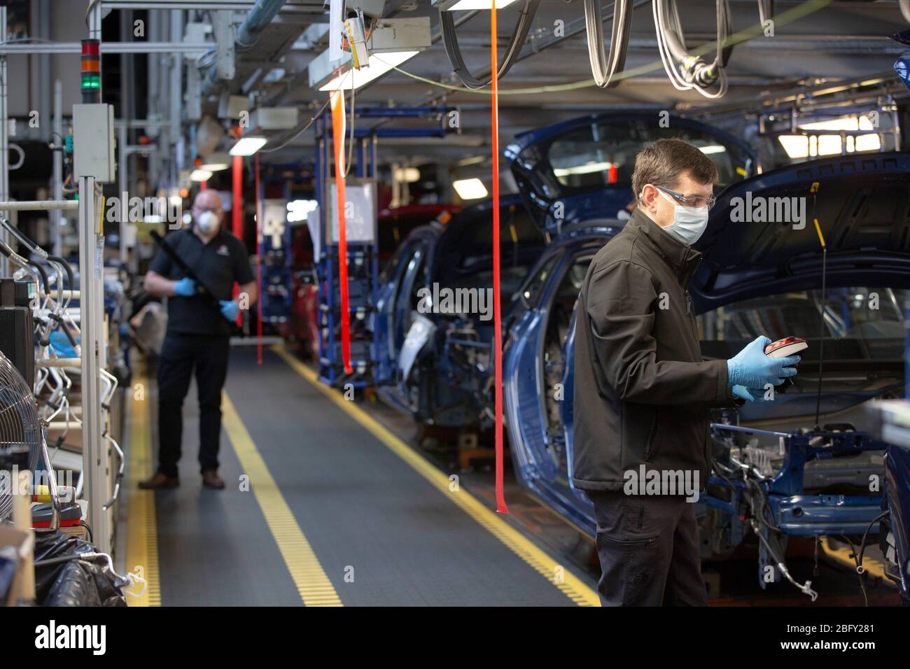 Membri del personale che lavorano tra stazioni di lavoro designate di due metri su una linea di assemblaggio di automobili presso lo stabilimento di Vauxhall durante i test di preparazione e la riprogettazione prima della riapertura a seguito dell'epidemia di COVID-19. Situato a Ellesmere Port, Wirral, la fabbrica è stata inaugurata nel 1962 e attualmente impiega circa 1100 lavoratori. Ha cessato la produzione il 17 marzo 2020 e riprenderà i lavori solo su parere del governo britannico, che comporterà l'adozione di severe misure di distanza fisica in tutto il sito. Foto Stock