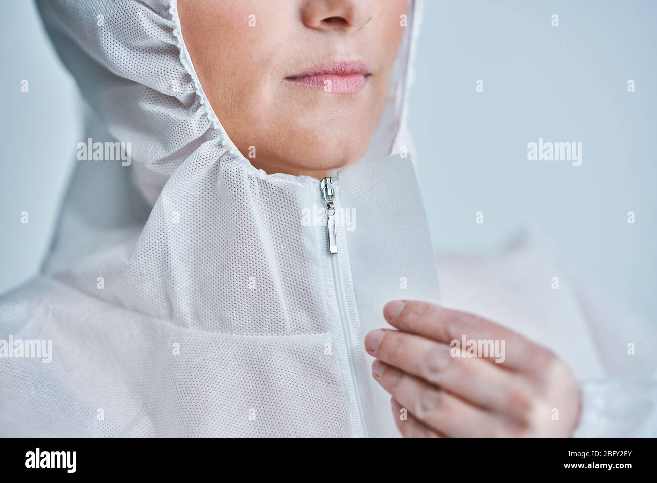 Donna in tuta a rischio biologico su sfondo bianco. Foto Stock
