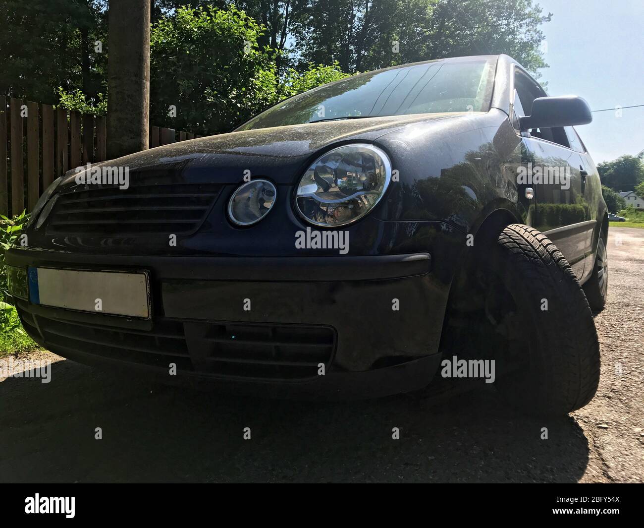 Ruota danneggiata di una vettura causata da un foro in una strada rurale. Una ruota strappata dall'assale corroso sulla vettura. Foto Stock