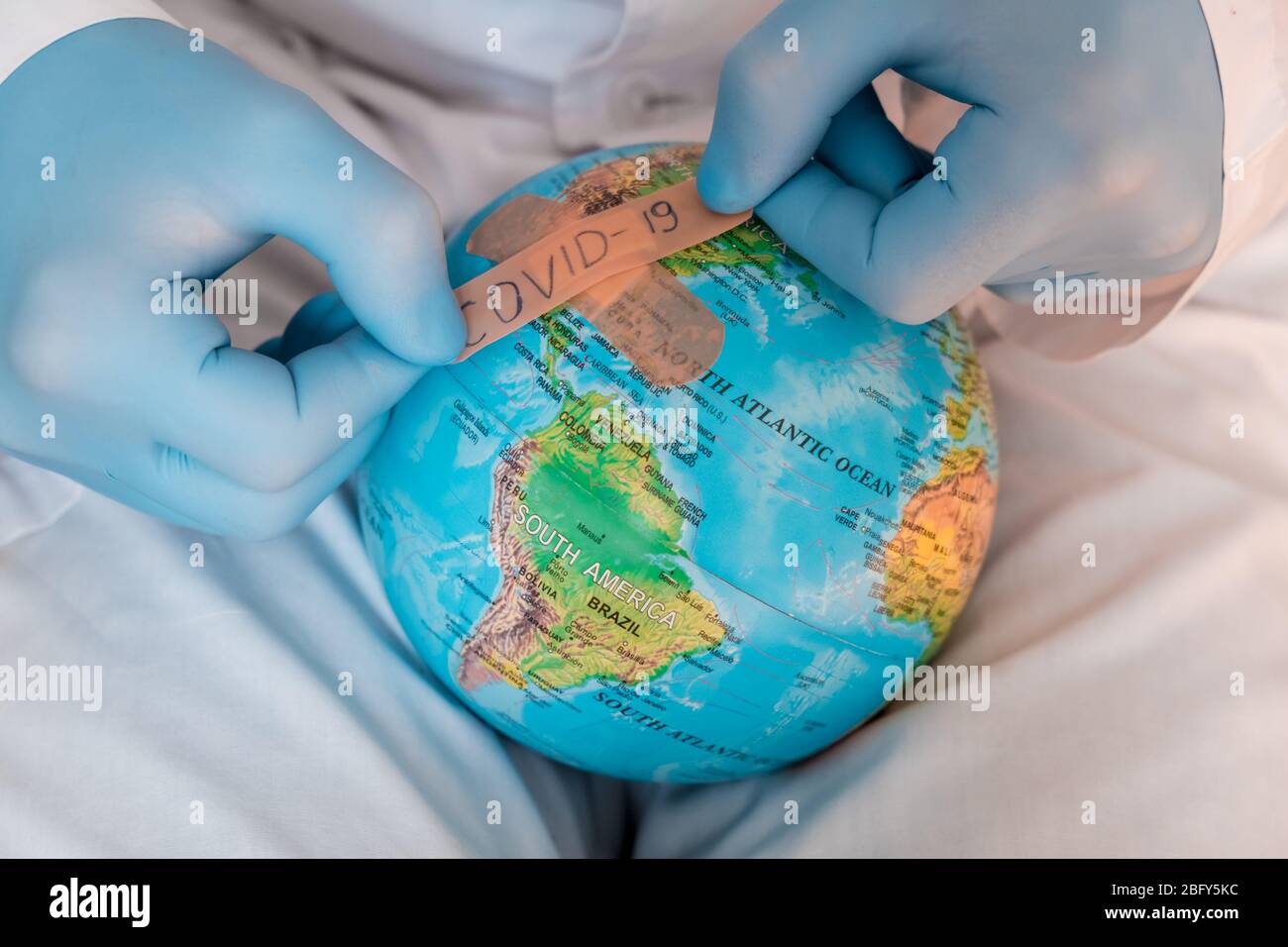 Globo mondiale con maschera medica verde su di esso. Concetto di epidemia di coronavirus. Concetto per la diffusione mondiale della disperazione di Coronavirus.. Foto Stock