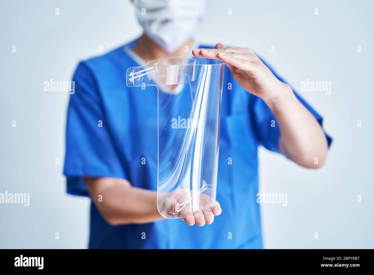 Ritratto di medico femminile che indossa maschera protettiva e visiera protettiva Foto Stock