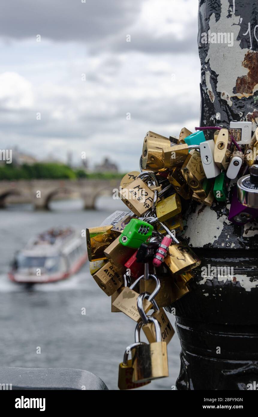 Primo piano di lucchetti d'amore sul Pont des Arts con la Senna visto sullo sfondo Foto Stock