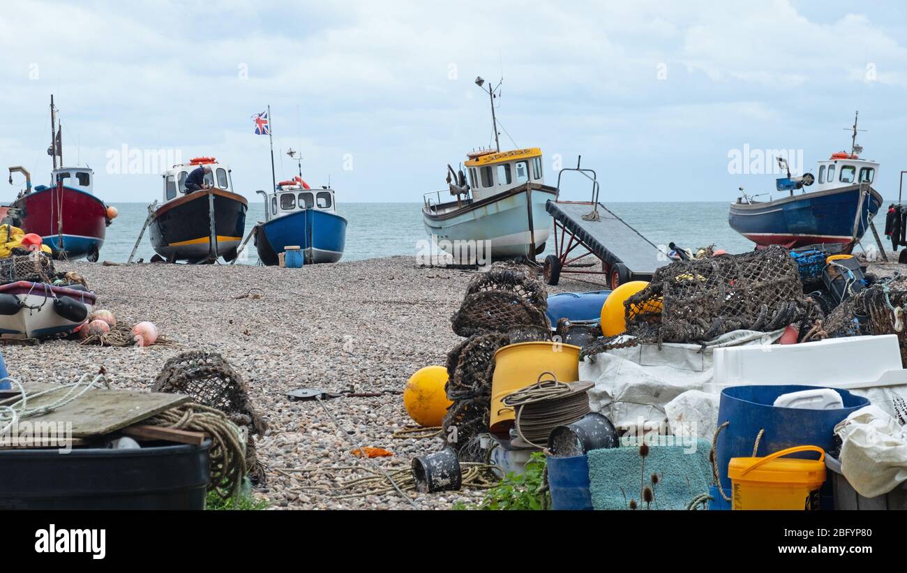 Birra, Inghilterra – 13 novembre 2019: Un pescatore non identificato che lavora su una delle barche della flotta di pesca locale si è bloccato sulla spiaggia di ghiaia Foto Stock