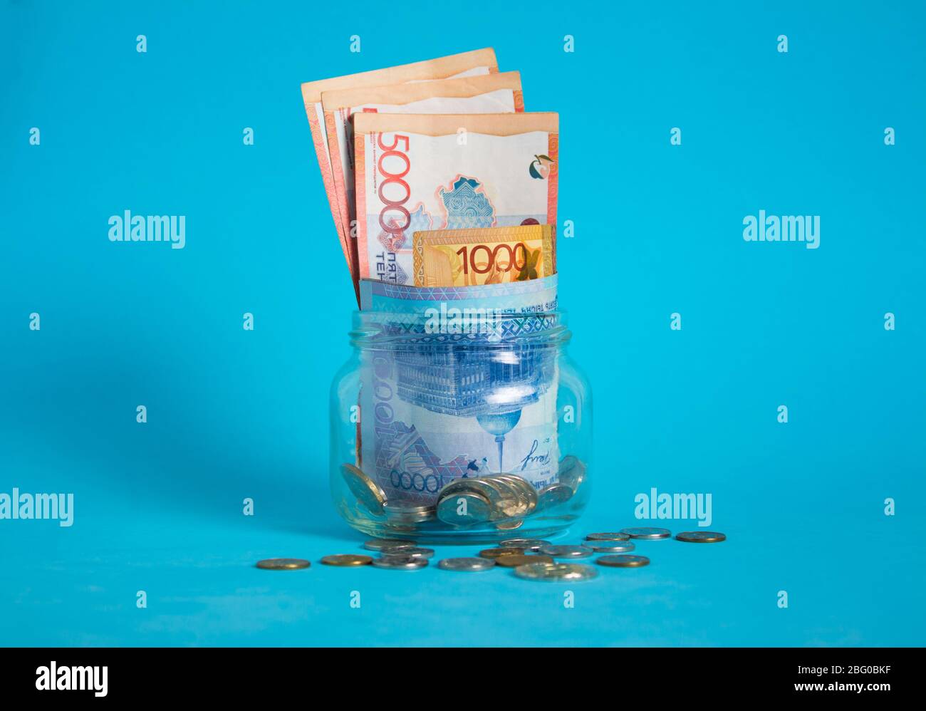 Tinge in un vaso di vetro. Kazakistan, KZ, KZT. Banconote, banconote, monete, Banca. Stipendio, credito, risparmio, paga e spendi. Economia e affari. Foto Stock