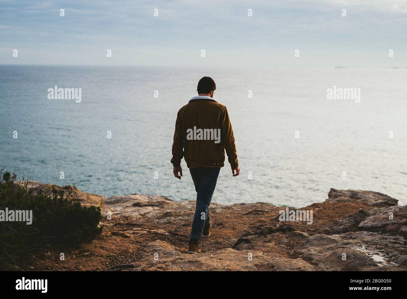 Ritratto di giovane uomo che cammina al mare all'aperto Foto Stock