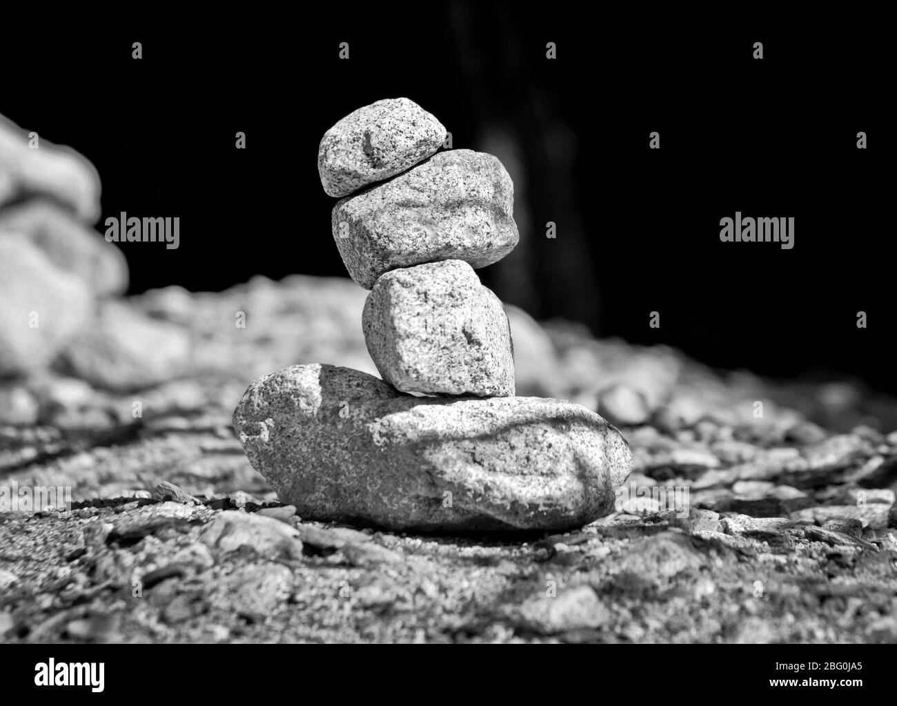 Piramidi di pietra, piccolo uomo, tumulo, ovoo, Inukshuk costruito per la vostra calma e tranquillità fatta vicino al lago o fiume di montagna in bianco e nero Foto Stock