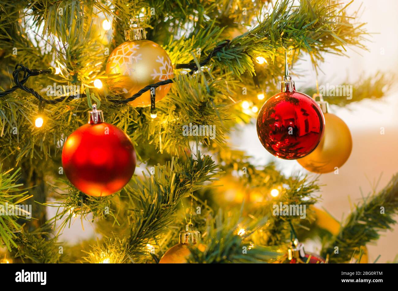 Decataglia di un albero di Natale con barboli e luci appesi. Messa a fuoco selettiva. Foto Stock