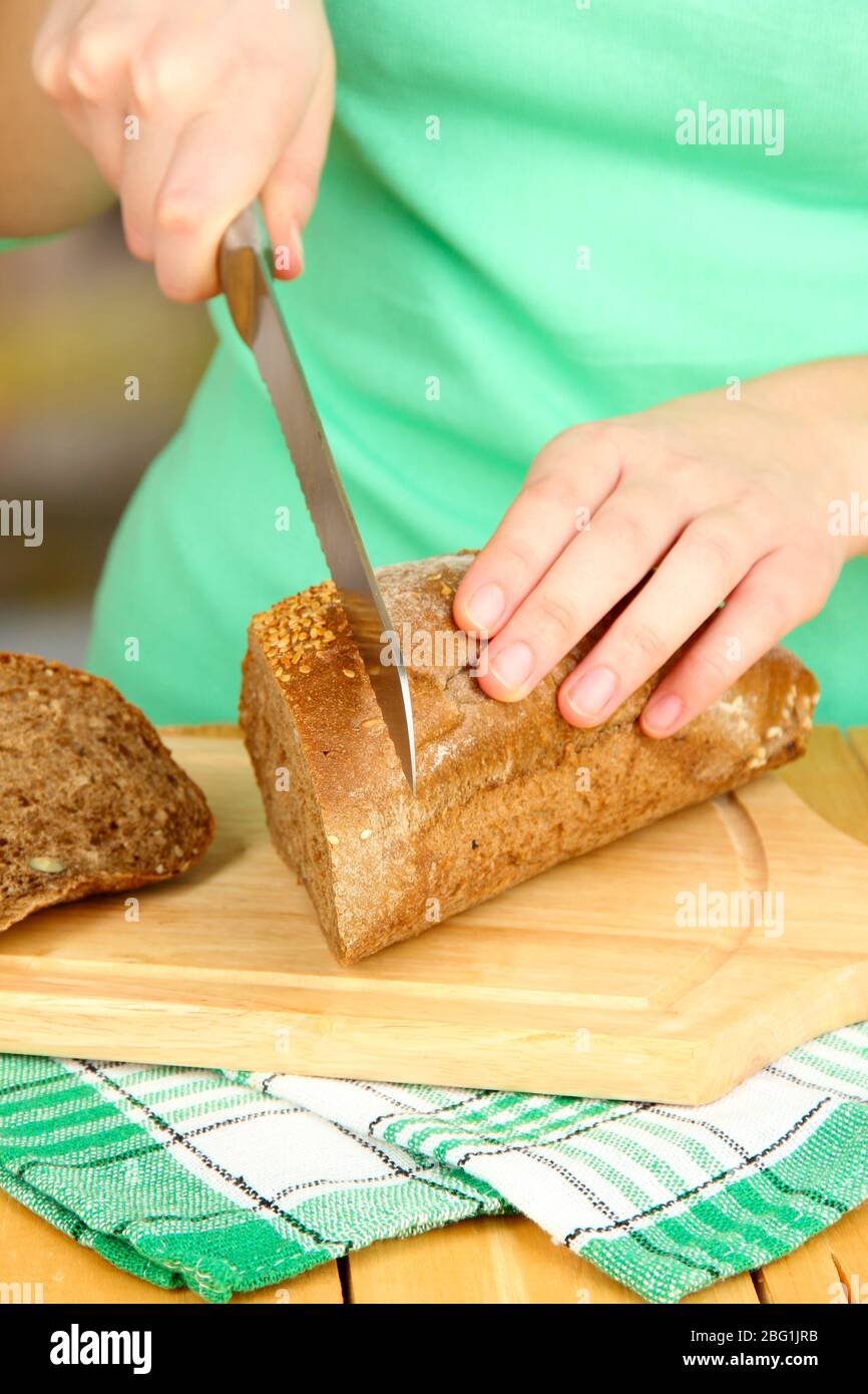 Donna che affetta il pane con semi di sesamo su tagliere, primo piano Foto  stock - Alamy