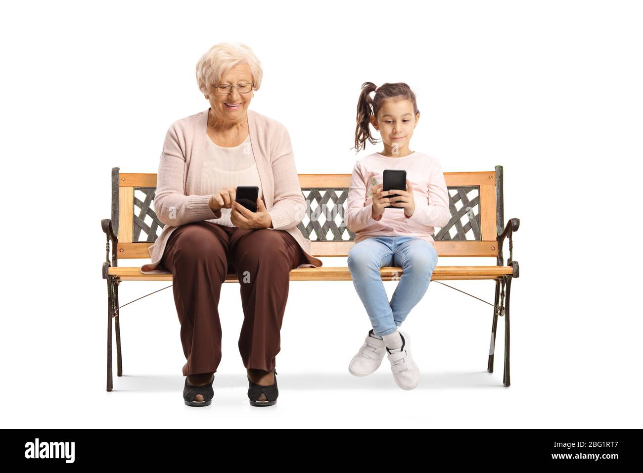 Bambino e una donna anziana seduta su una panchina e digitando su telefoni cellulari isolato su sfondo bianco Foto Stock