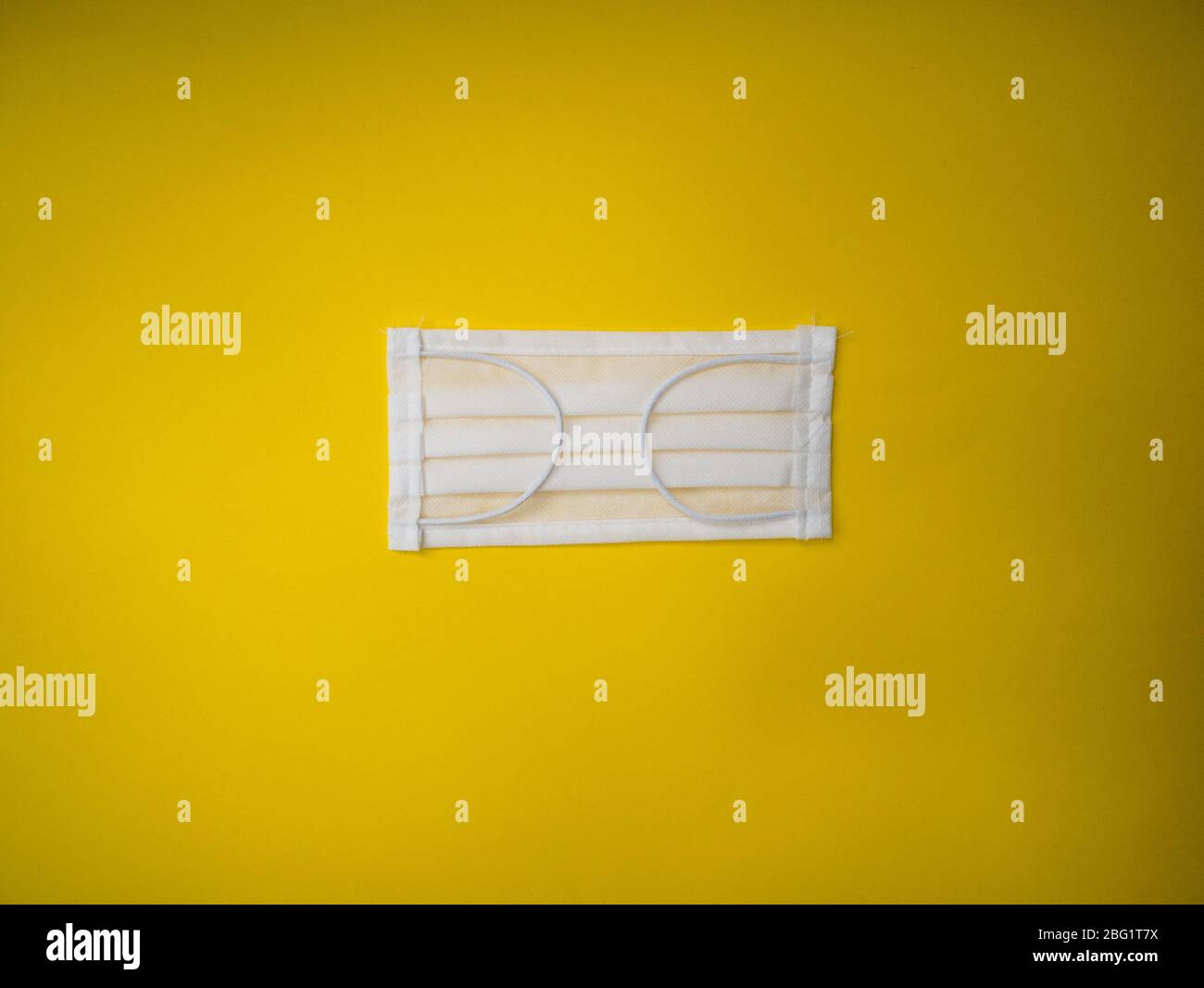 Maschera chirurgica con cinghie in gomma per le orecchie. Tipica maschera chirurgica a 3 strati per coprire bocca e naso. Maschera di procedura da batteri. Concetto di protezione. Foto Stock