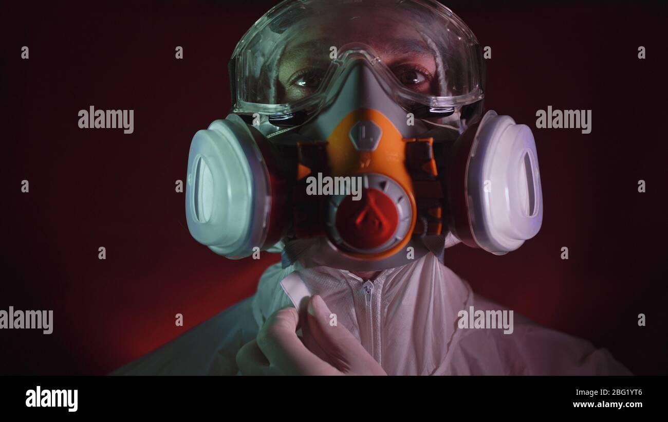 Uomo in costume protettivo, gas proteggere maschera di vernice spray medico. Medico in respiratore. Concetto di malattia virus coronavirus epidemia. Foto Stock