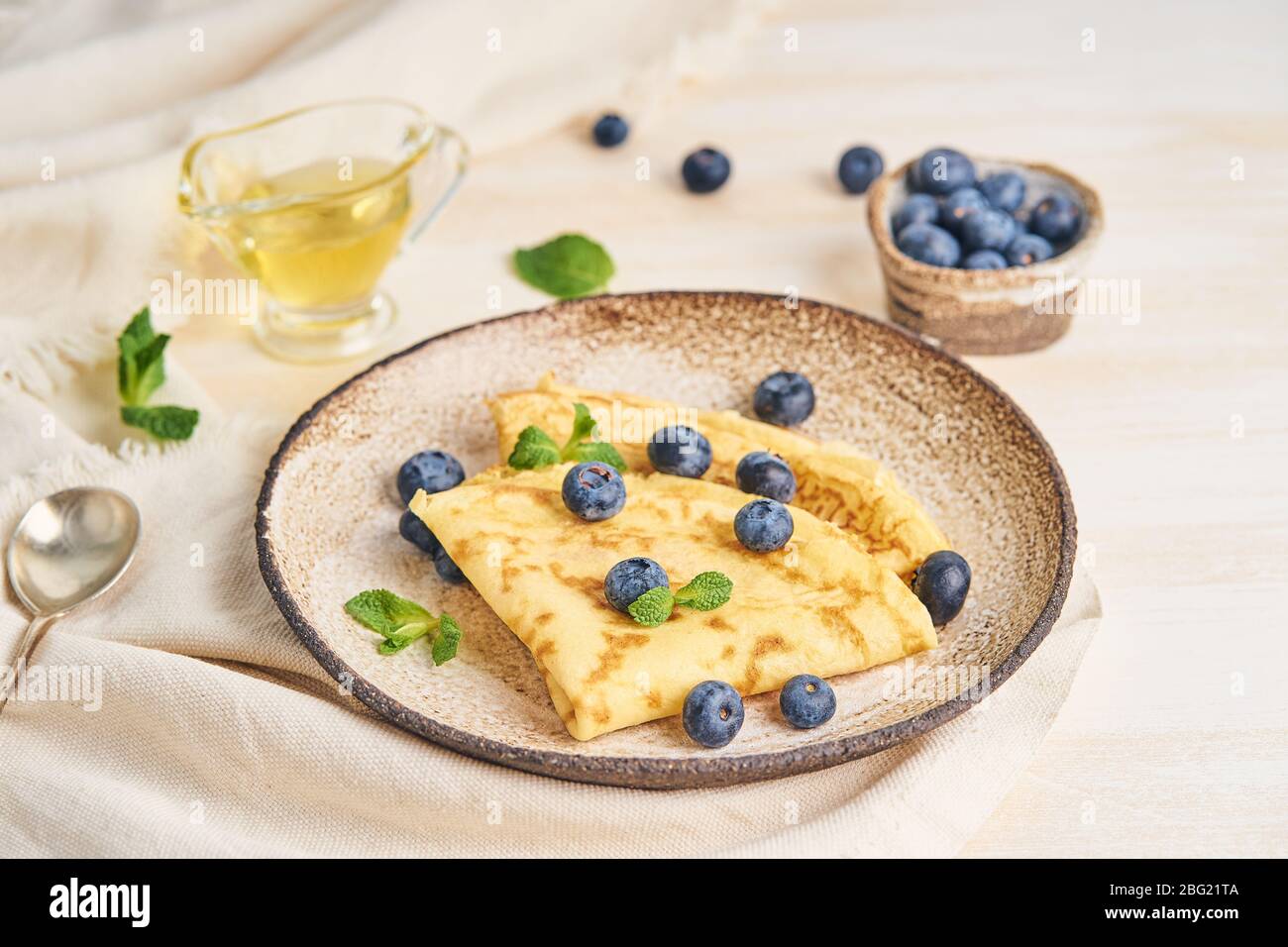 Due pancake con mirtilli e menta sul piatto, vista laterale Foto Stock