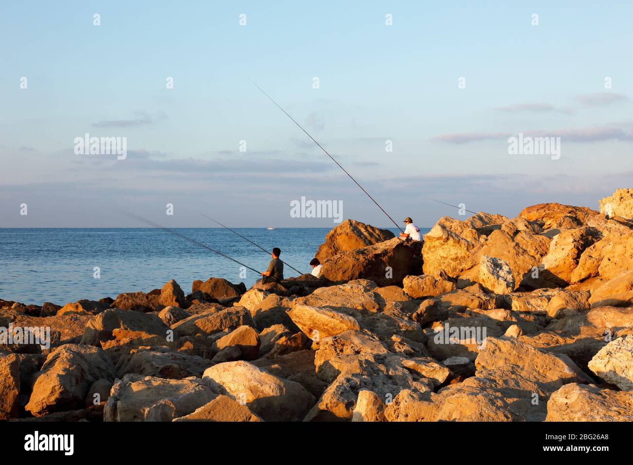 Pescatori pesca da rocce all'alba Foto Stock