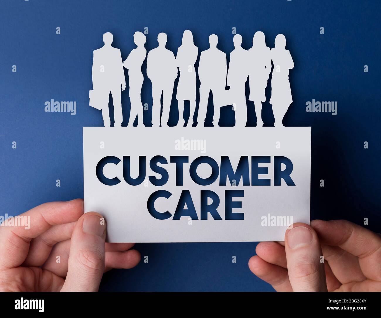 Mani che tengono un cliente cura il biglietto bianco le persone del team di affari segno Foto Stock