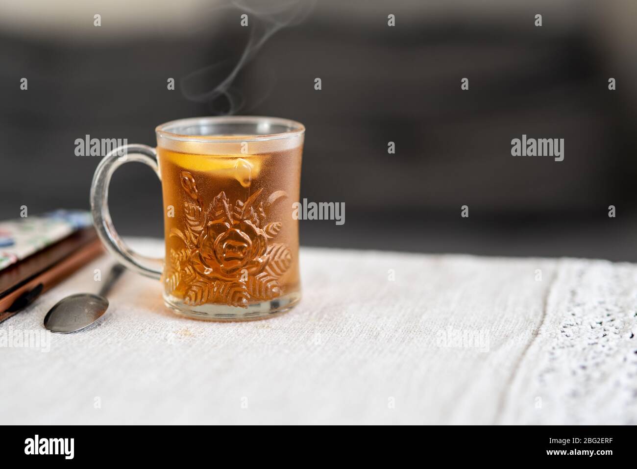 Un bicchiere di tè caldo con limone sul tavolo. Concetto di soggiorno a casa. CopySpace. Foto Stock