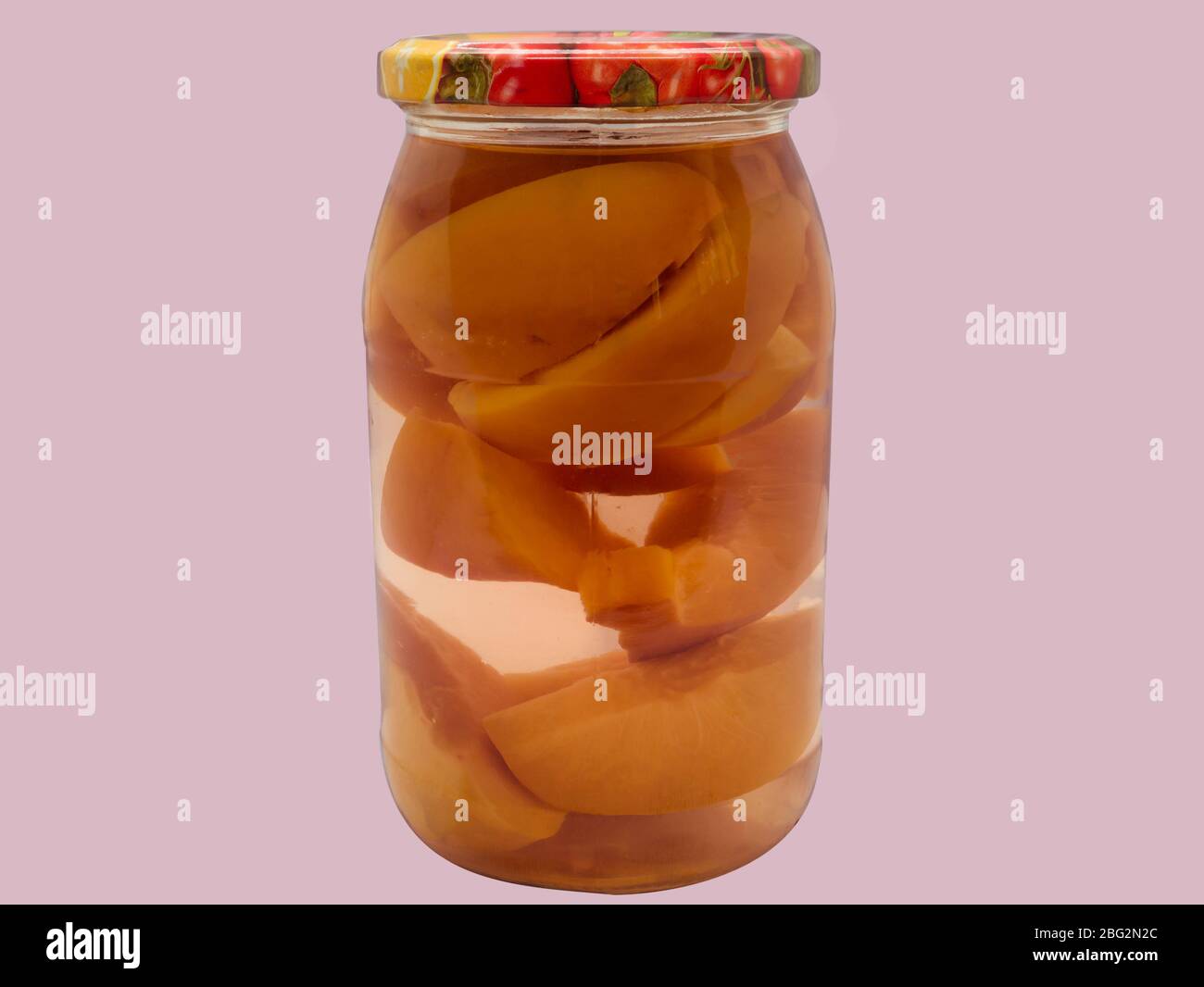 Composta di frutta fatta in casa. Composta di pesca in vaso di vetro su fondo rosa. Foto Stock