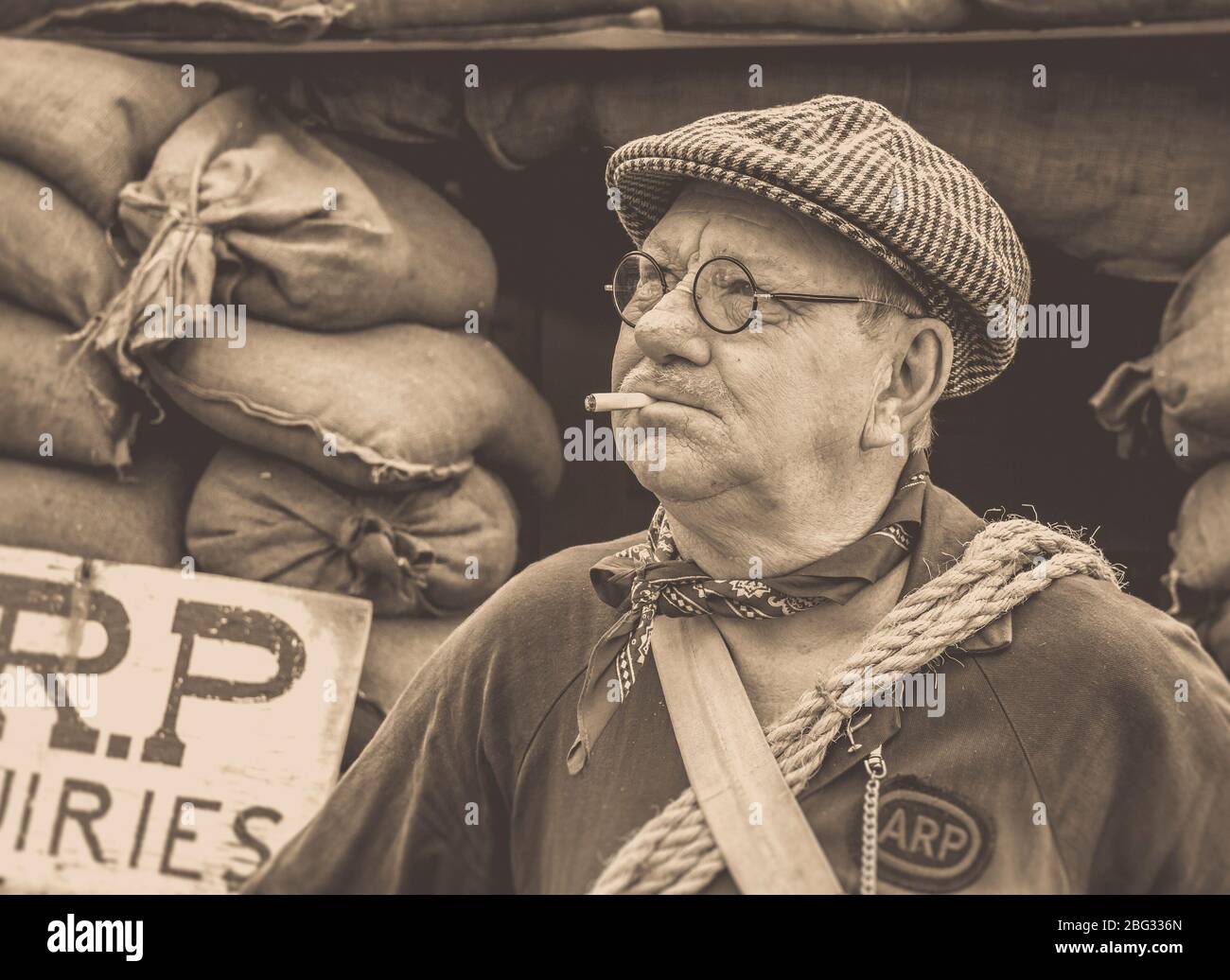 Vecchio stile, vista mono di uomo vestito come warden ARP anni '40 isolato all'aperto da rifugio, Severn Valley Railway 1940 WWII evento estivo, Regno Unito Foto Stock