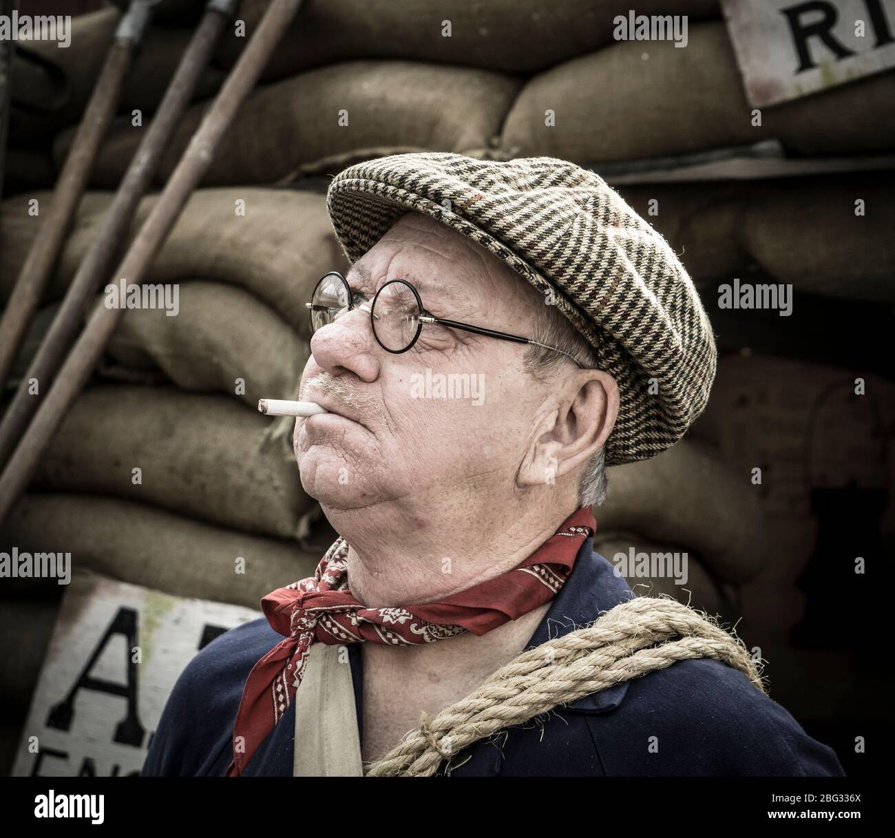 Primo piano di uomo isolato vestito in costume degli anni '40 con cappellino piatto come ARP vintage Warden by Air raid shelter Severn Valley Railway evento estivo degli anni '40, Regno Unito. Foto Stock