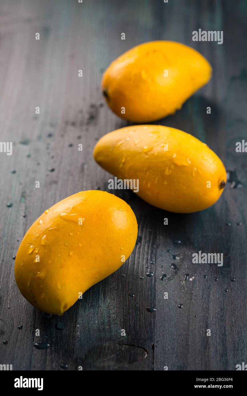 Frutta fresca di mango di miele su sfondo di legno. Ataulfo (mango) dal Messico. Foto Stock