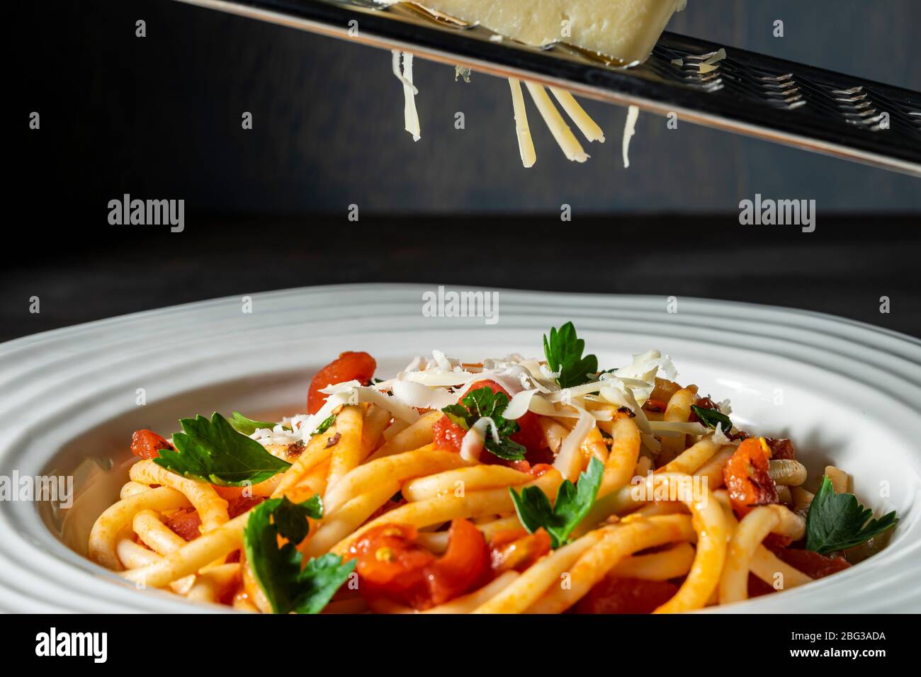 Asiago su un grattuggiatore su pasta. Foto Stock