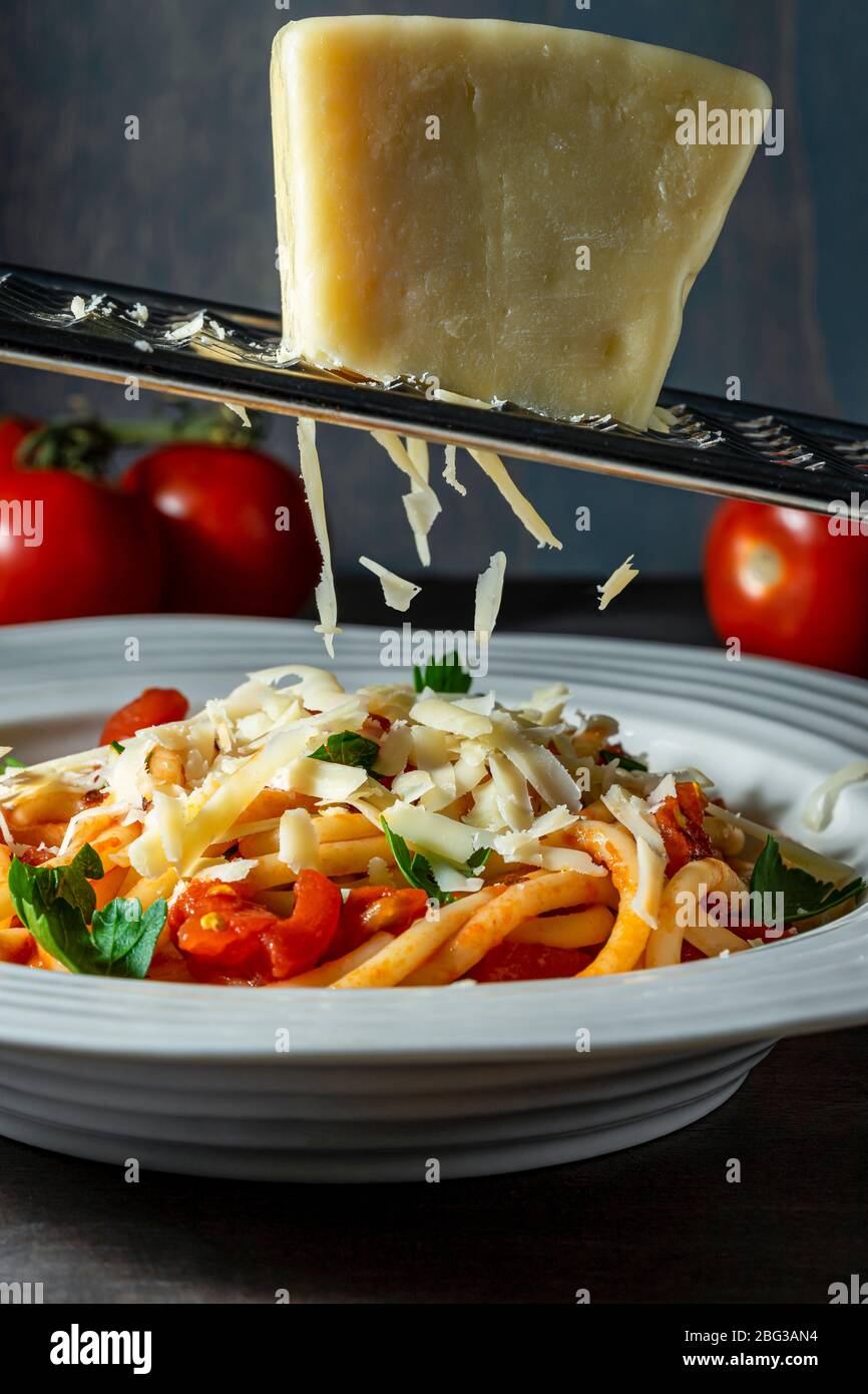 Asiago su un grattuggiatore su pasta. Foto Stock