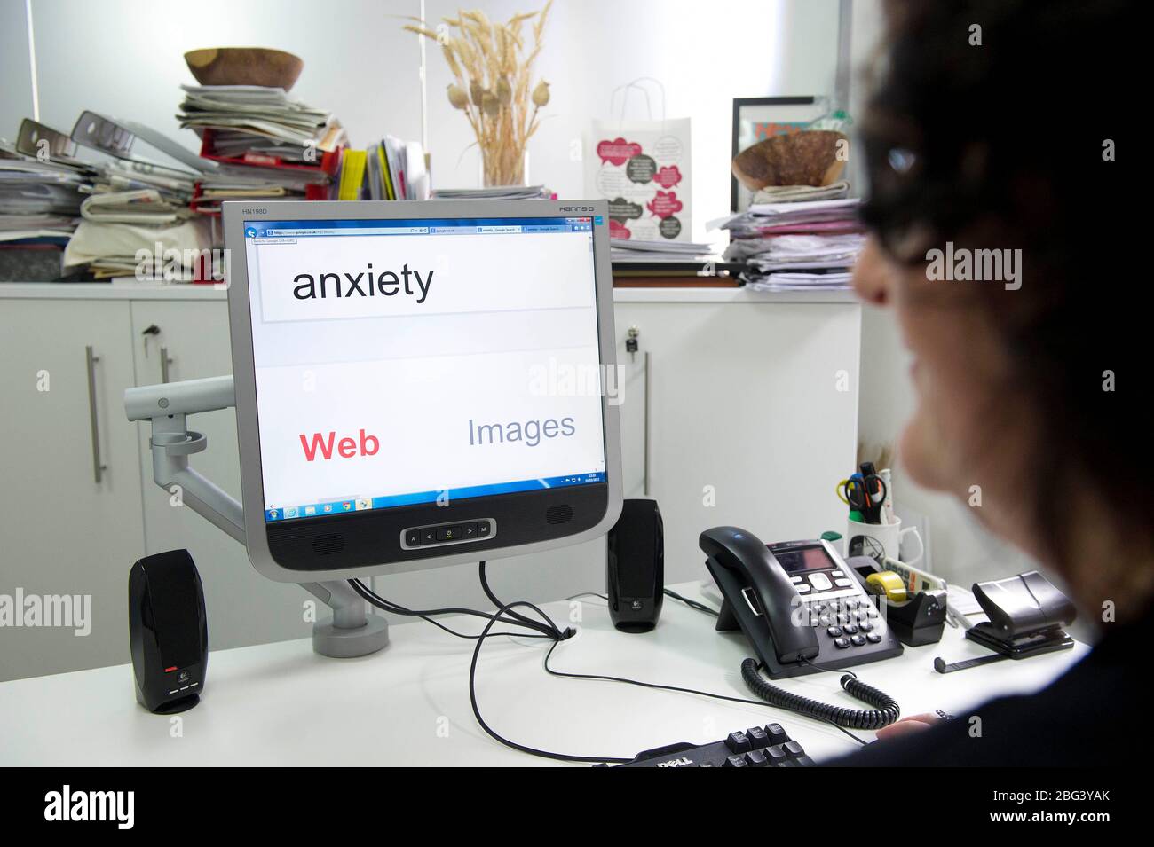 Un lavoratore di ufficio va su un motore di ricerca in linea per consiglio sull'ansia. Foto Stock