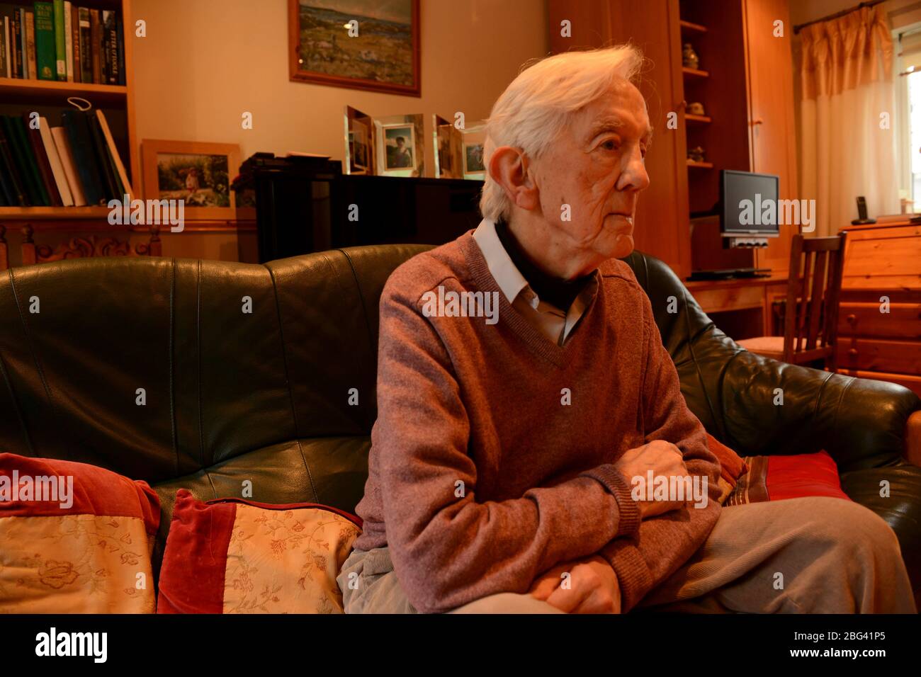 Un anziano che soffre di depressione siede da solo nel suo soggiorno Foto Stock