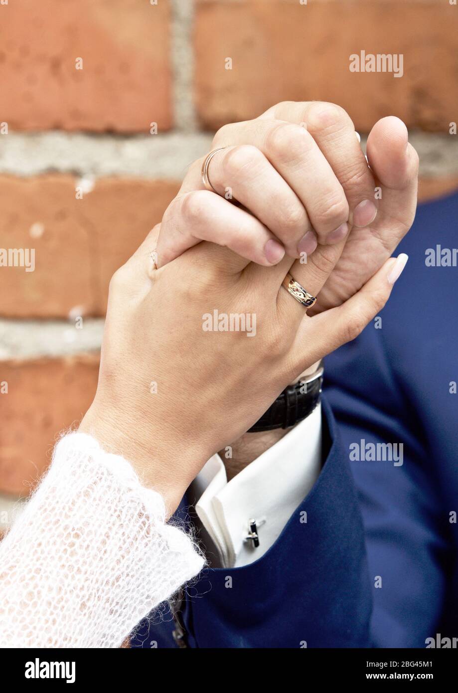 Close-up di una sposa e lo sposo tenendo le mani Foto Stock