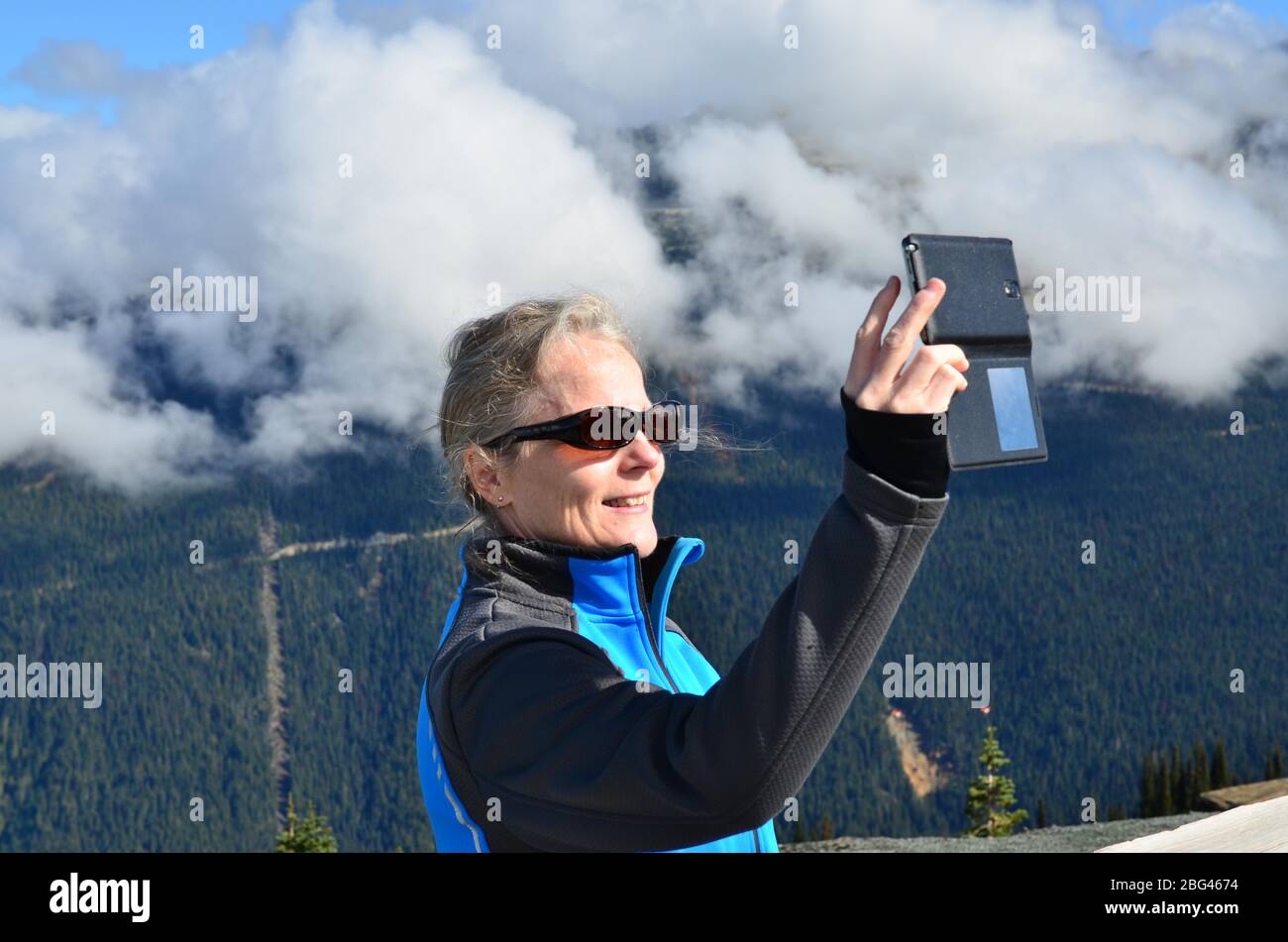 Ritratto di una donna sorridente che prende un selfie in montagna, Whistler, British Columbia, Canada Foto Stock