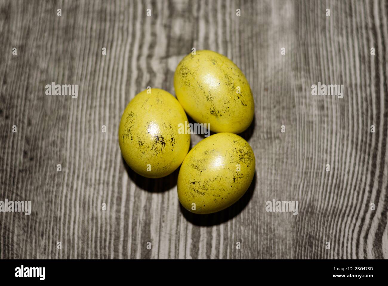 Tre uova gialle di pollo che si posano su sfondo di legno. Uova di Pasqua. Foto Stock