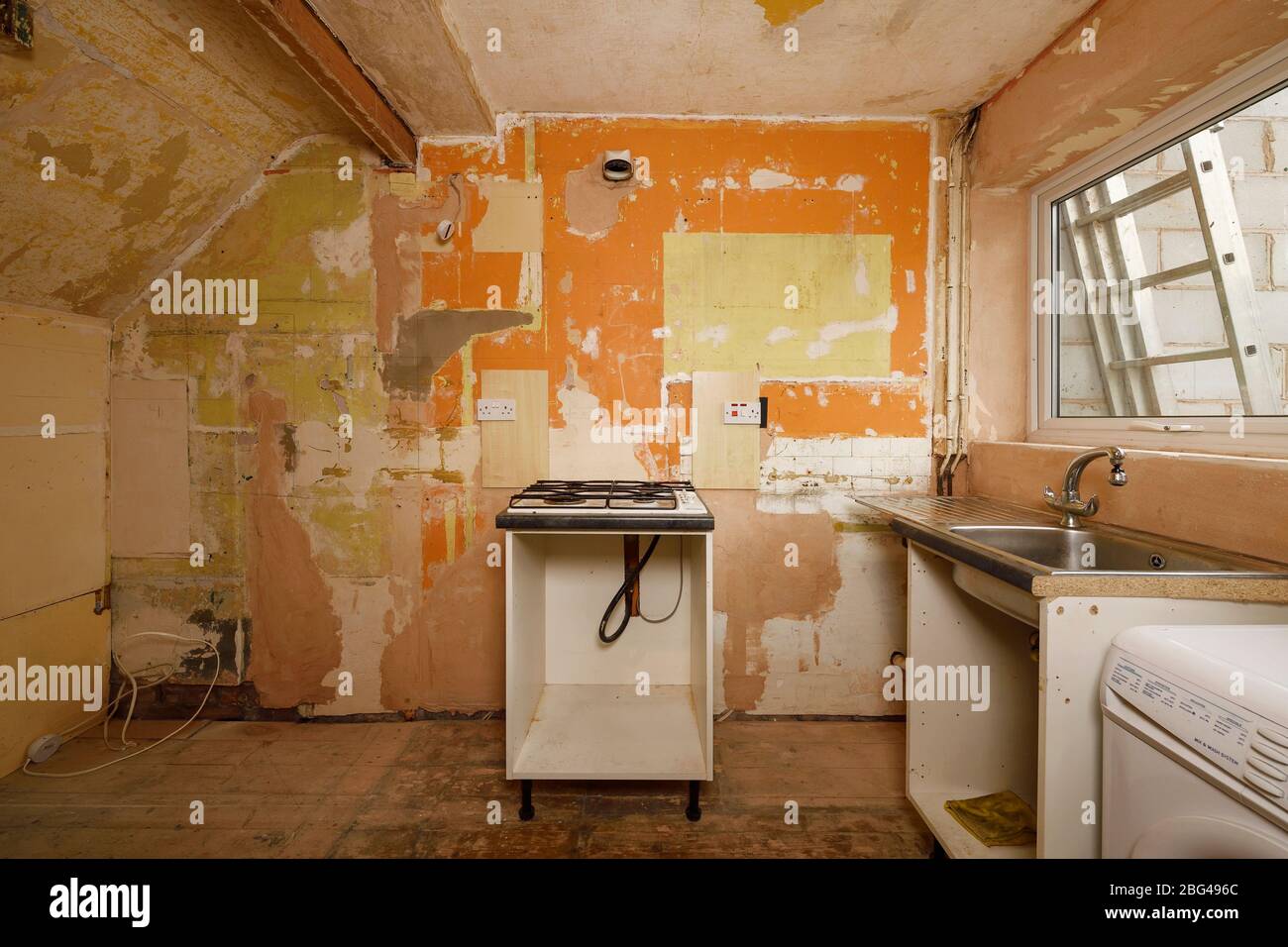 Una vecchia cucina si è spogliata alle pareti nude durante un progetto di ristrutturazione Foto Stock