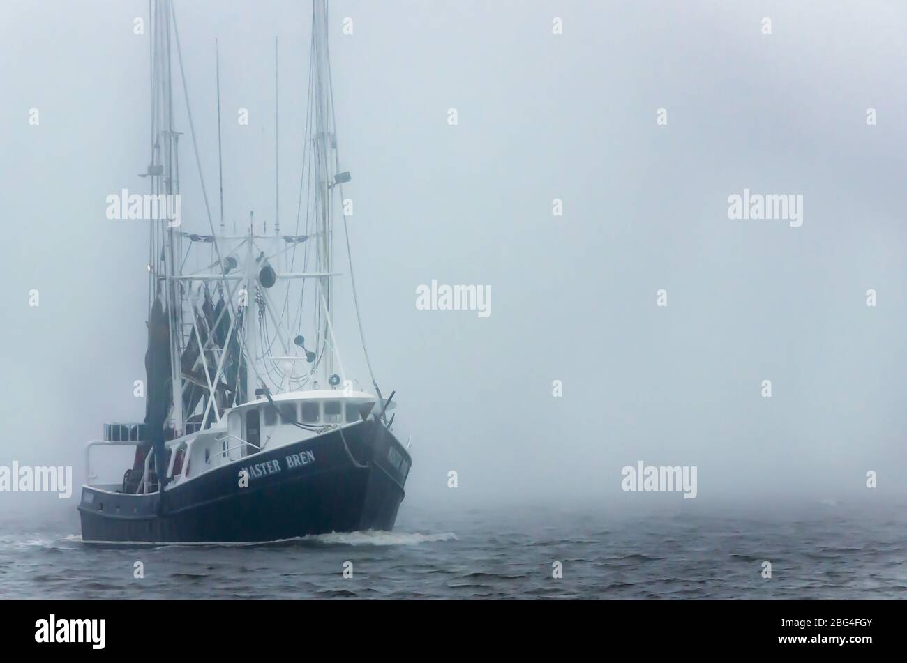 Una barca di gamberi si dirige a casa in una giornata di nebbia, 8 febbraio 2017, a Bayou la Batre, Alabama. Foto Stock