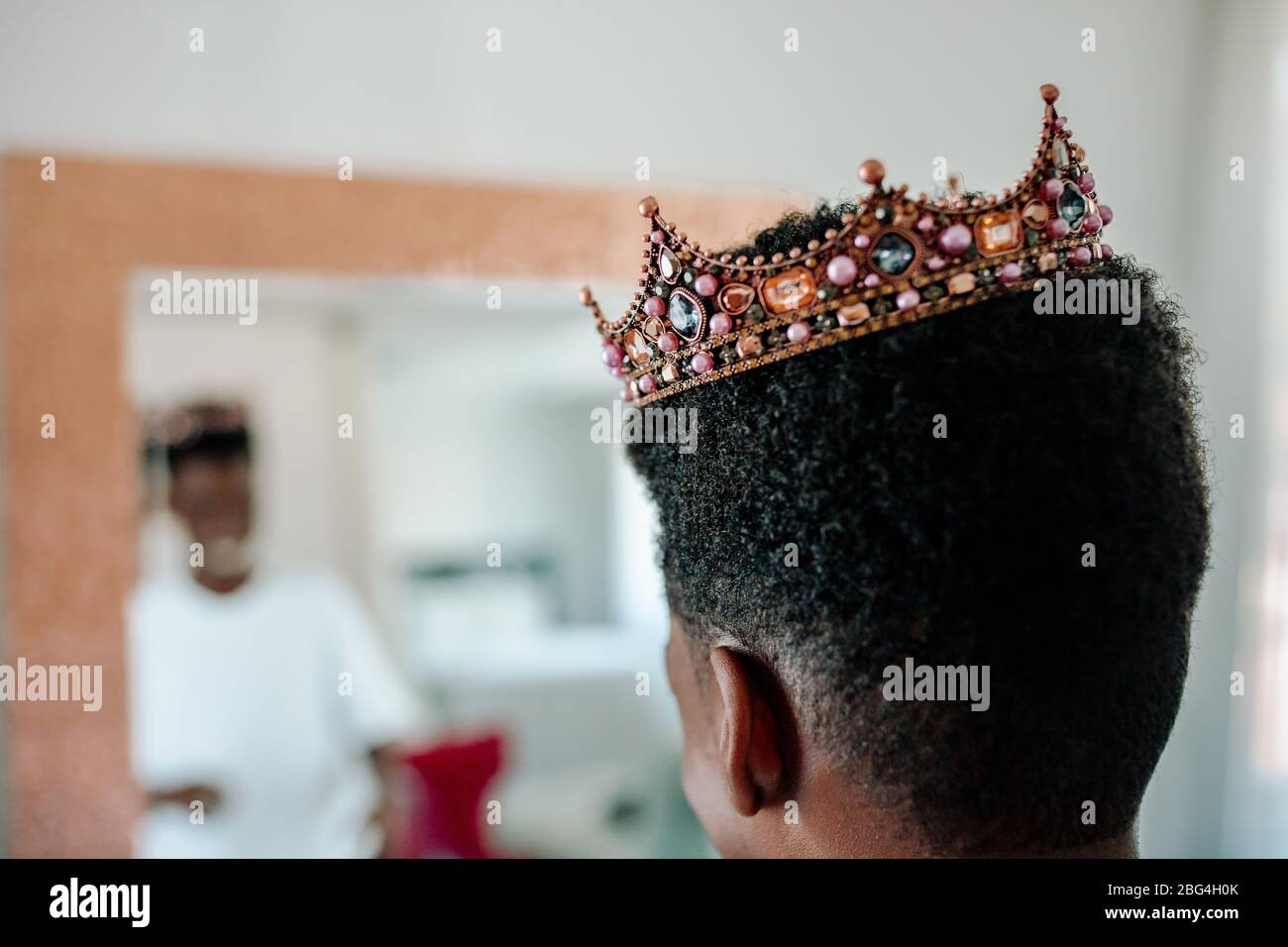 Ragazzo afro-americano con corona orlata e specchio Foto Stock