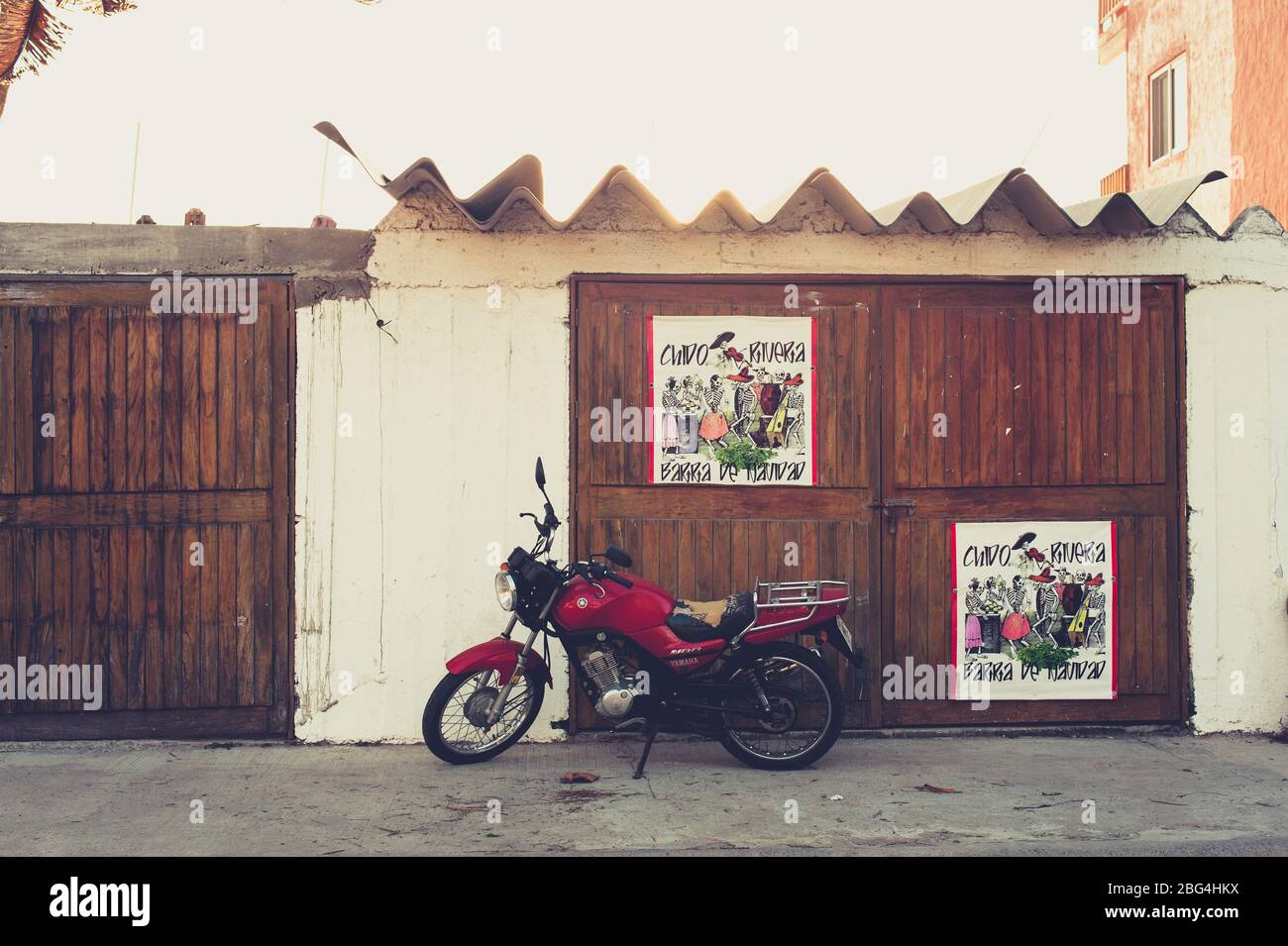 Moto rosso vintage di fronte alla porta in legno in Messico Foto Stock