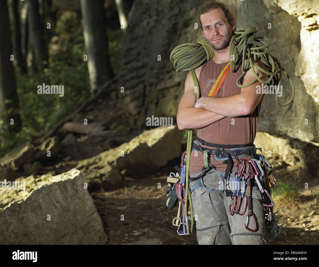 scalatore di roccia che posò con corda da arrampicata sulle spalle Foto Stock