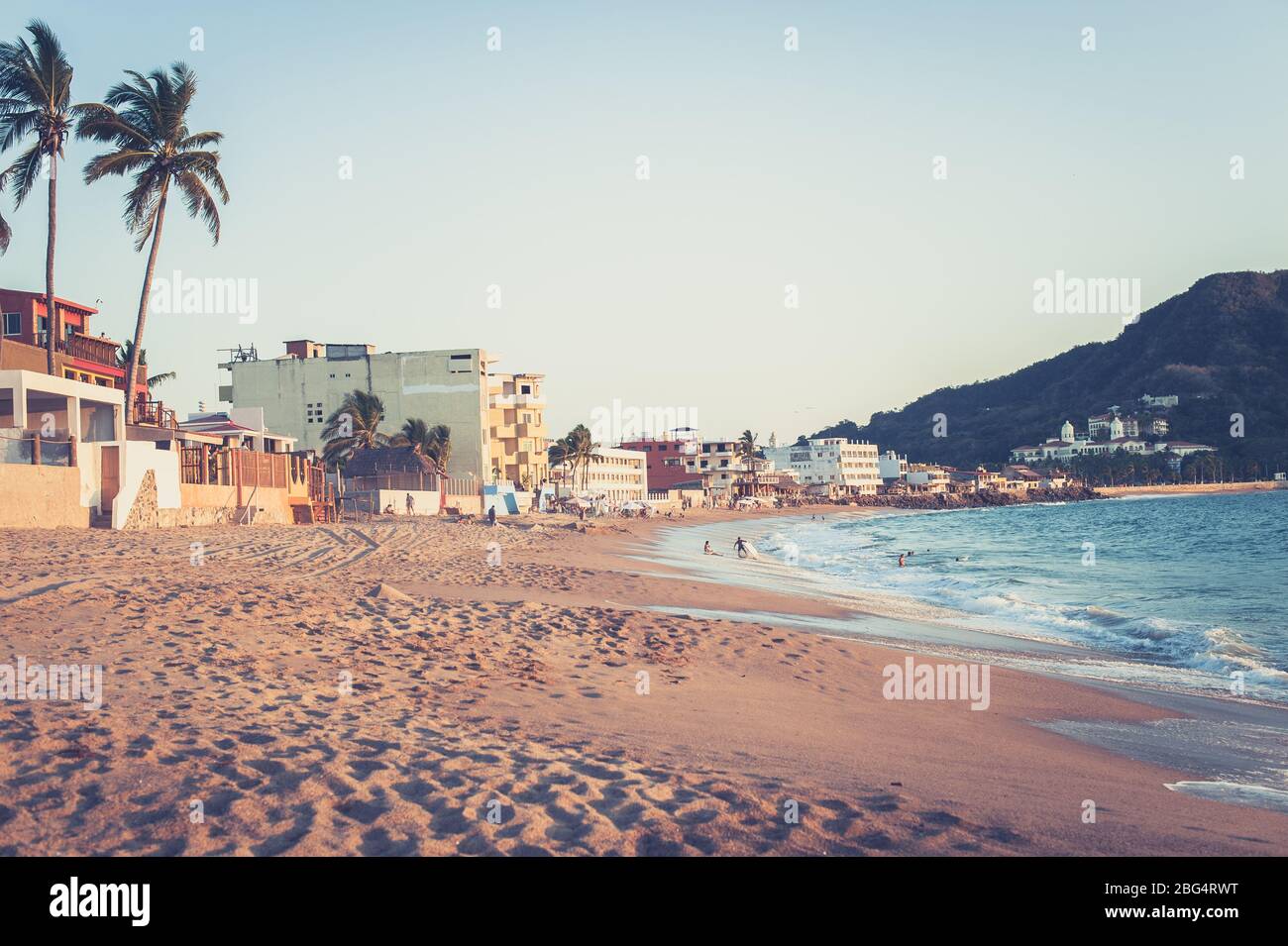 Piccola cittadina sulla spiaggia in Messico e onde che si infrangono al tramonto Foto Stock