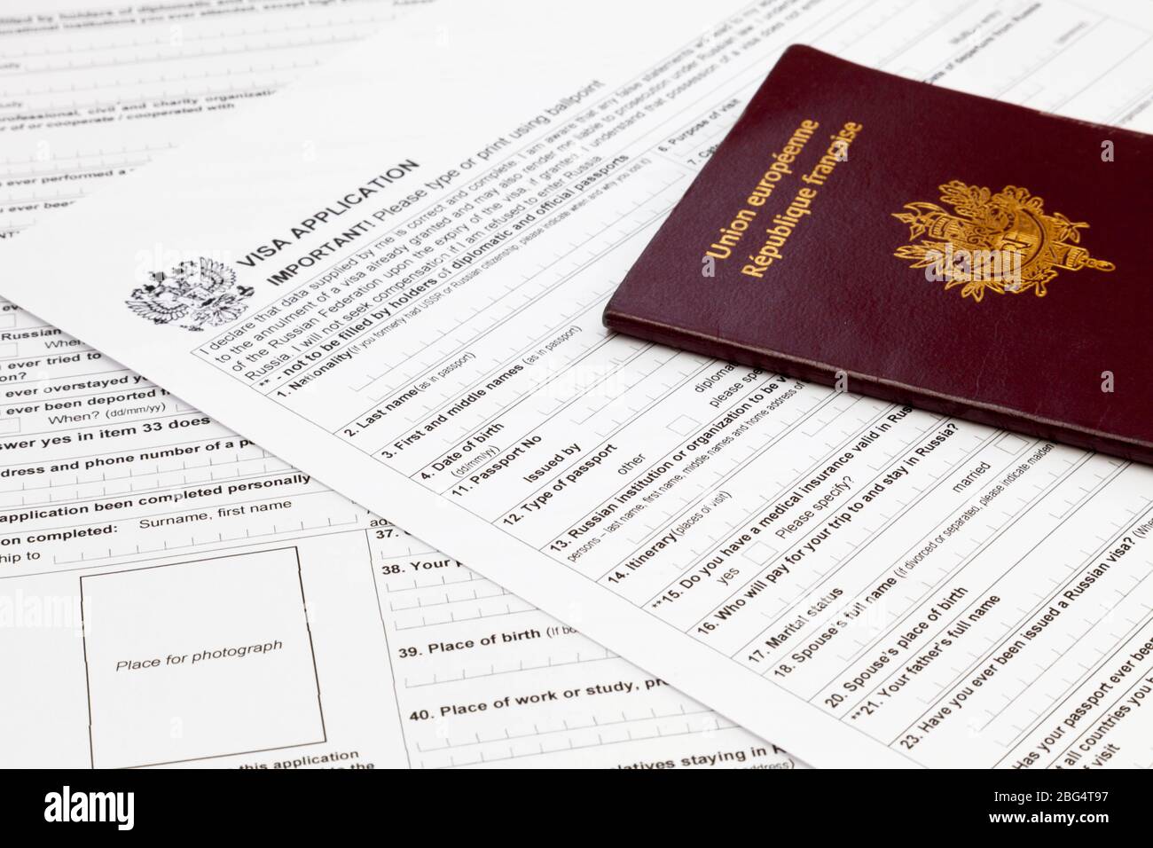 Un passaporto francese in cima ad un modulo di domanda di visto russo. Foto Stock