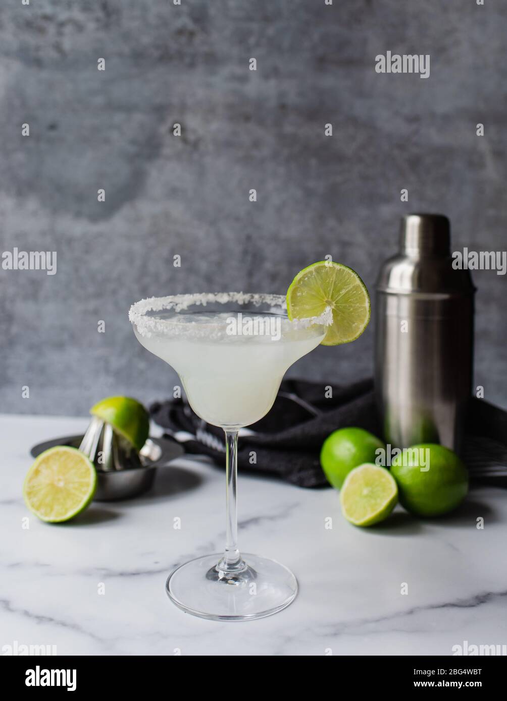 Primo piano del cocktail margarita con lime e shaker su bancone in marmo Foto Stock