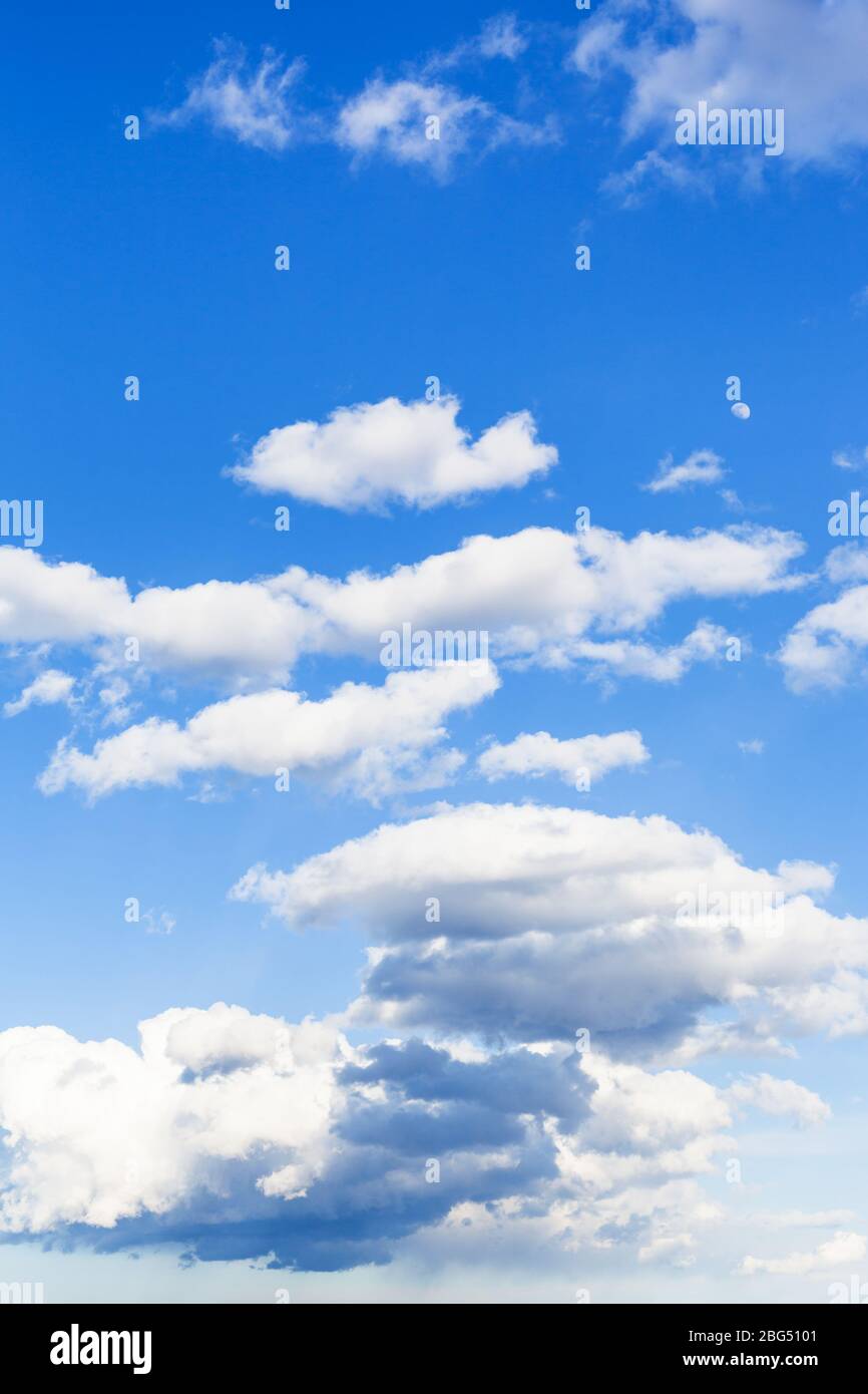 Nuvole basse e scure e alte nuvole bianche nel cielo blu il giorno di marzo Foto Stock